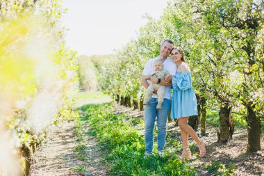 Genç bir evli çift, bir erkek, bir kadın ve küçük bir oğlan parkta yürüyorlar. Yürüyüş zamanı, anne, baba ve küçük çocuk..