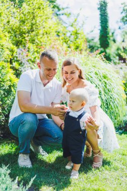 İki ebeveyn yeni yürümeye başlamış oğullarıyla oynuyorlar. Genç bir evli çift, bir erkek, bir kadın ve küçük bir oğlan parkta yürüyorlar. Yürüyüş zamanı, anne, baba ve küçük çocuk..