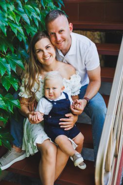 İki ebeveyn yeni yürümeye başlamış oğullarıyla oynuyorlar. Genç bir evli çift, bir erkek, bir kadın ve küçük bir oğlan parkta yürüyorlar. Yürüyüş zamanı, anne, baba ve küçük çocuk..