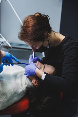 Ağız bakımı. Kadın dişlerinde diş teli sistemi. Dişleri hizalamak için diş telleri kurulumu.