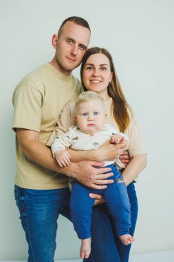 Küçük bir oğlu olan mutlu bir aile çifti. Anne, baba ve bebek sarılıyor..