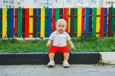 Yazın yürüyüşe çıkan beyaz tişörtlü ve şortlu bir çocuk. Çocuk koşuyor ve temiz havada oynuyor..