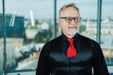 Sakallı yaşlı adam gözlük takıyor. Yaşlı büyükbabanın çatısı düşüyor ve yüzünü buruşturuyor..