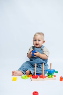 Bebek çocuk çocuk odasında oynarken bir bulmaca çözücüyle oynuyor. El becerilerini geliştirmek için oyuncaklar.