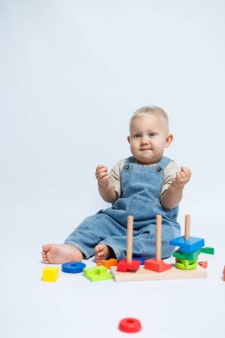 Bebek çocuk çocuk odasında oynarken bir bulmaca çözücüyle oynuyor. El becerilerini geliştirmek için oyuncaklar.