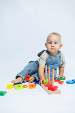 Bebek çocuk çocuk odasında oynarken bir bulmaca çözücüyle oynuyor. El becerilerini geliştirmek için oyuncaklar.