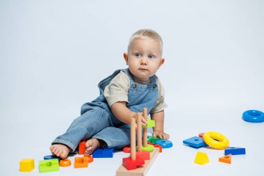 Bebek çocuk çocuk odasında oynarken bir bulmaca çözücüyle oynuyor. El becerilerini geliştirmek için oyuncaklar.