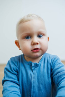 Yüzünde farklı duygular olan bir yaşındaki küçük bir çocuk. Duygusal bir bebek. Neşeli çocuk. Mavi gözlü küçük çocuk..