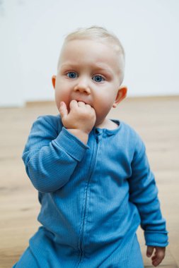 Yüzünde farklı duygular olan bir yaşındaki küçük bir çocuk. Duygusal bir bebek. Neşeli çocuk. Mavi gözlü küçük çocuk..