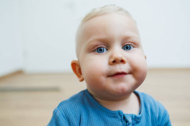 Yüzünde farklı duygular olan bir yaşındaki küçük bir çocuk. Duygusal bir bebek. Neşeli çocuk. Mavi gözlü küçük çocuk..