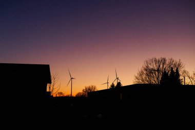 Gün batımında rüzgar türbini enerji üretimi. Elektrik bir rüzgar türbini tarafından üretilir. Ekolojik enerji üretimi