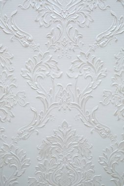 Beyaz bir duvarda desen var. Duvardaki desenlerin dokusu.