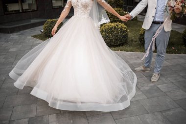 Gelin ve damat düğün günlerinde. Sevgi dolu bir çiftin kucaklaşmaları, el ele tutuşmaları.