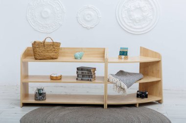 Güzel, minimalist, ahşap bir raf. Şık, çağdaş bir ortamda çeşitli dekoratif eşyalarla süslenmiş.