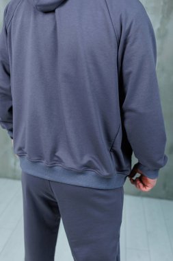 Görüntü, eşofman altı ve rahat bir stil sergileyen sıradan giyinmiş bir kişinin arka görünüşünü gösteriyor.