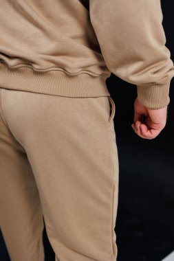 Rengarenk bir kazak giymiş bir bireyin arka görünüşü ve şık ve rahat bir haki rengi pantolon.