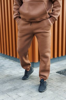 Kahverengi takım elbiseli bir adam. Soğuk yürüyüşler için erkek postu. Erkek modası.