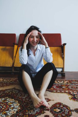 Bir kadın, rahat ve davetkar bir odada otururken derin yansımalarını nazikçe ifade eder.