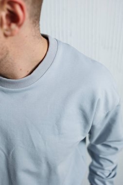 Bu resim, benzersiz doku ve tasarım unsurlarını vurgulayan modern gri bir sweatshirt 'ün yakın plan görüntüsünü içerir.