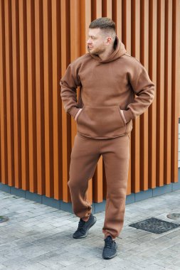 Kahverengi takım elbiseli bir adam. Soğuk yürüyüşler için erkek postu. Erkek modası.