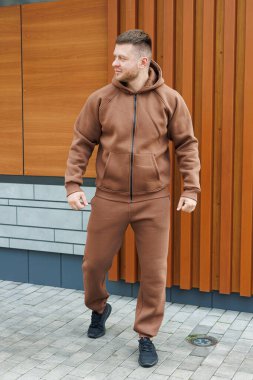 Kahverengi takım elbiseli bir adam. Soğuk yürüyüşler için erkek postu. Erkek modası.