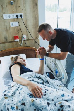 Bir hastayla partnerinin hastane odasında sevgi ve ilgiyi yansıtan samimi bir an..