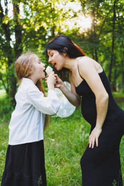 Dışarıda dondurmayı paylaşan sevgi dolu bir anne ve kızı arasında gerçekten neşeli ve iç açıcı bir an.