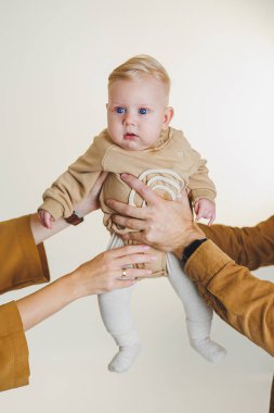 Sevgi dolu bir bebek, sevgi dolu ebeveynler tarafından tutulur. Modern bir aile ortamında neşe ve şefkat gösterilir.
