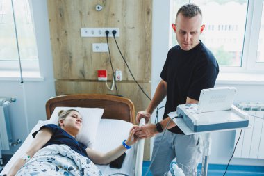 Karı koca doğum odasında bir çocuğun doğumuna hazırlanıyorlar. Koca, doğum sırasında karısına destek oluyor. Kadın kocasının huzurunda doğum yapıyor.