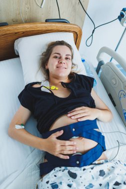 Bir hasta hastane yatağında dinleniyor, tıbbi ekipmanlarla çevrili, umut verici bir iyileşme ruhu yayıyor.