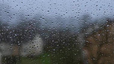 Şeffaf camdan aşağı su damlaları akıyor. Pencereye yağmur damlıyor. Pencereye yağmur damlaları.