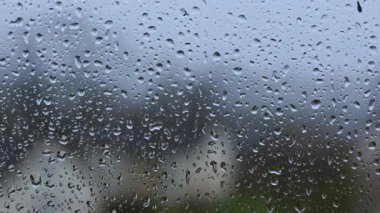 Şeffaf camdan aşağı su damlaları akıyor. Pencereye yağmur damlıyor. Pencereye yağmur damlaları.