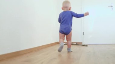 Küçük çocuk bir paspasla yerleri yıkıyor. Çocuk yerleri temizlemeye yardım ediyor. Pamuklu elbiseli bir çocuk..