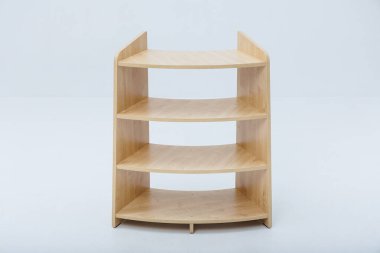 Üç sağlam raftan oluşan güzel bir ahşap raf, doğal estetiğini geliştiren temiz, beyaz bir zemin üzerine kurulmuş.