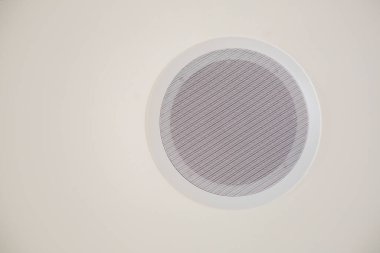 Düz beyaz bir duvara yerleştirilmiş beyaz dairesel bir havalandırma deliği var. Bu da amacına hizmet ediyor.