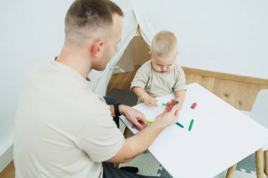 Kendini işine adamış bir baba, ufaklıkla kaliteli vakit geçirmeyi, renkli sanat malzemeleriyle yaratıcılığı beslemeyi, destekleyici ve neşeli bir atmosferde erken gelişimi teşvik etmeyi sever.
