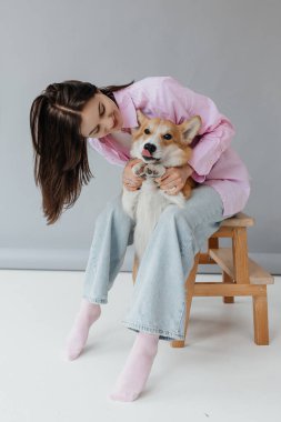 Gülümseyen bir kadın ve Corgi 'si arasında paylaşılan neşeli bir an derin aşklarını ve dostluklarını gösteriyor.