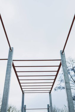Çarpıcı bir tırmanış çerçevesi gri, bulutlu bir gökyüzüne karşı duruyor. Yenilikçi açık hava fitness kavramları için ideal bir yer.