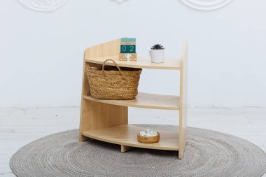 Üzerinde belirgin bir sepet ve zarif bir saat bulunan taşralı ahşap bir raf uzaya cazibe katıyor.