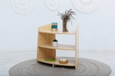 Üzerinde zarif bir şekilde yerleştirilmiş güzel bir vazo ile süslenmiş ahşap bir raf.