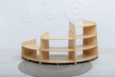 Konforlu bir odada, güzel kıvrımlı bir ahşap raf zarif bir halının üzerinde uzaya hem cazibe hem de işlevsellik katar.