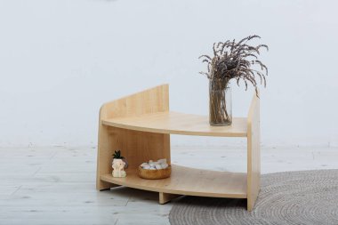 Zarif bir vazo ve dekoratif eşyalarla süslenmiş, modern yaşam alanları için mükemmel bir köşe masa.