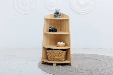 En alttaki rafta, işlevselliği doğal estetikle birleştiren şık bir sepetin bulunduğu güzel bir ahşap raf.