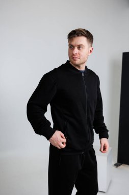 Şu anda bir adam şık siyah bir ceket giyiyor. Eşleşen siyah bir pantolon giyiyor. Şık ve uyumlu bir kıyafet yaratıyor.