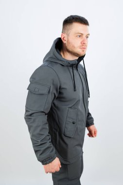 Bir adam şu anda şık gri bir ceket giyiyor. İçinde çeşitli hava koşulları ve moda ifadeleri için mükemmel bir başlık var.