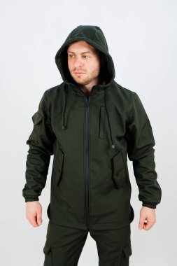 Bir adam canlı yeşil bir ceket giyiyor, rahat bir başlığı var, serin havalarda sıcak tutmak için mükemmel.