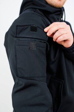 Giysinin kolunda uygun bir cep bulunan şık siyah bir ceket giyen bir adam görülebilir.