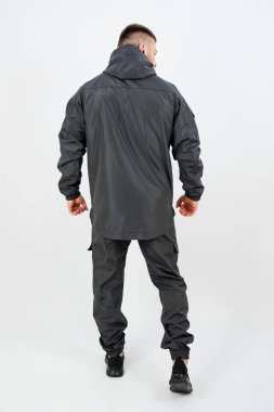 Tarz sahibi, siyah bir ceket giymiş, aynı siyah pantolona sahip, moda ve pratik anlayışı yakalayan bir adamın arka planı.