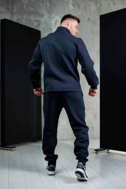 Aynı siyah pantolona sahip şık bir siyah ceket giymiş modern moda anlayışını sergileyen bir adamın dikiz aynasıdır.