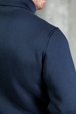 Manzara mavi kapüşonlu bir adamın arkasına odaklanıyor, çeşitli tekstil ve moda tarzlarını sergiliyor.